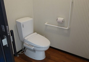 清潔感のあるトイレ室。温水洗浄便座と手すりが完備されている。